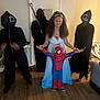 Symone is registered to the contest to win money with this photo: child, girl, costume, spiderman, ghostface, squid_game, indoor, floor, door, dress, mask, group, party, fun, celebration, halloween, person, young, holding_hands, wood_floor