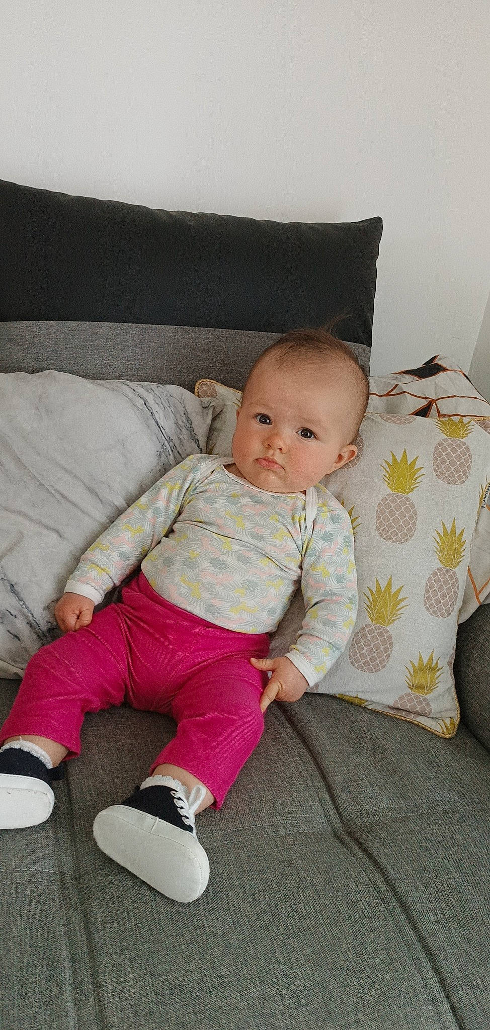 Loëlyne participe au concours pour gagner de l'argent avec cette photo : baby, baby_toddler_clothing, cheek, child, comfort, couch, flooring, foot, human_leg, knee, lap, linens, pattern, person, room, sitting, sleeve, sock, throw_pillow, toddler