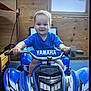 Lanie joined the competition — help win amazing prizes! toddler, child, toy, quad_bike, yamaha, blue, indoor, wooden_wall, window, temperature_display, rain_icon, smiling, young_child, handlebars, vehicle, play, person, furniture, floor, casual_clothing