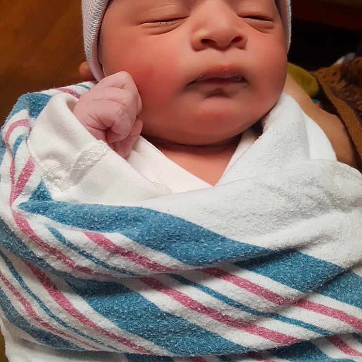 Ahsan joined the competition — help win amazing prizes! baby, blanket, bonnet, cap, clothing, face, glove, hat, head, newborn, person, photography, portrait, quilt, sleeping, towel