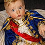 Karson joined the competition — help win amazing prizes! baby, child, crown, blue_clothing, gold_embroidery, red_sash, costume, portrait, royalty, regal, surprised_expression, face, hand, indoor, fabric, lace, jewelry, young_child, closeup, person