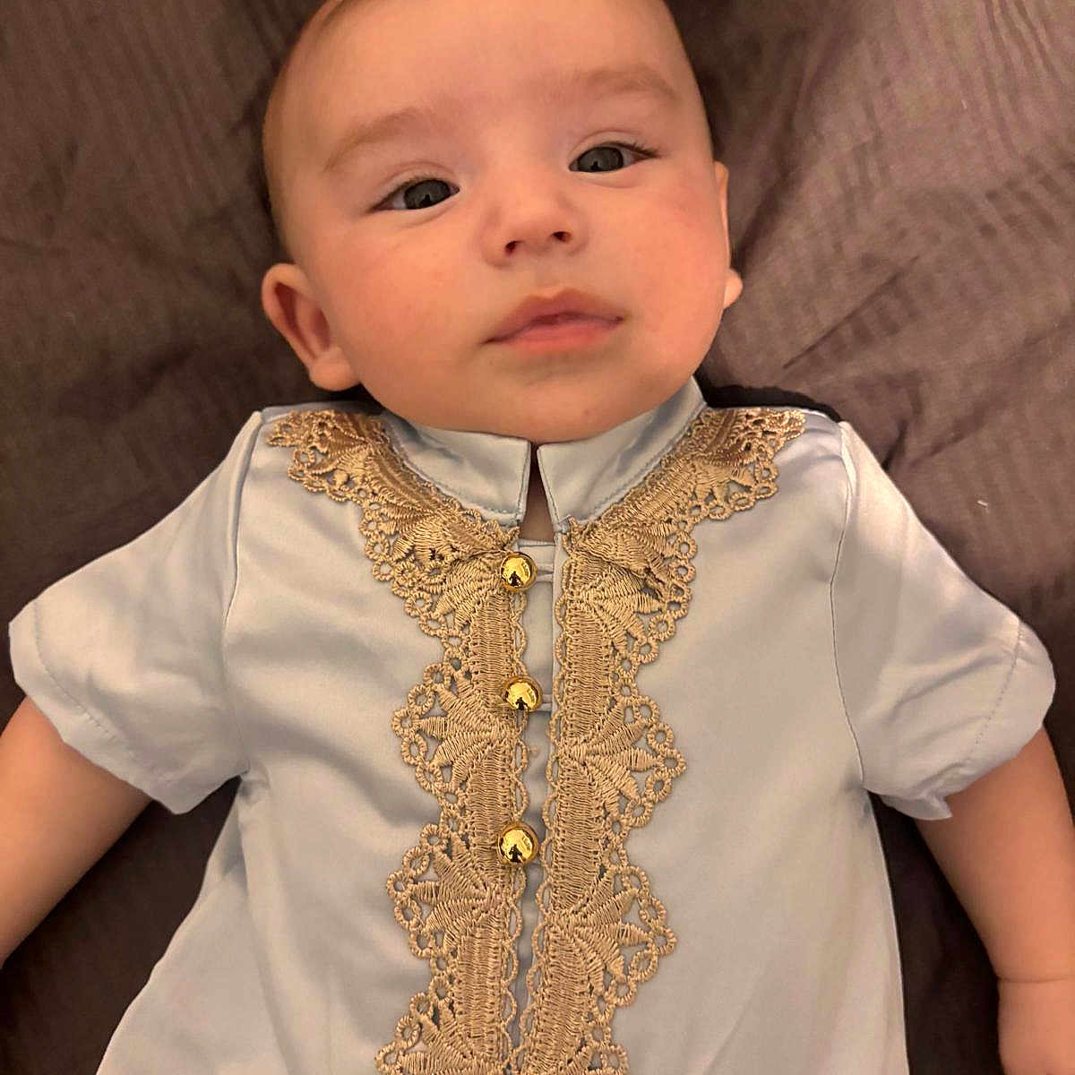 Ali participe au concours pour gagner de l'argent avec cette photo : baby, calm, child, clothing, cute, dress, eyes, fabric, face, golden_embroidery, hand, head, indoors, infant, laying_down, person, portrait, skin, soft_texture, young