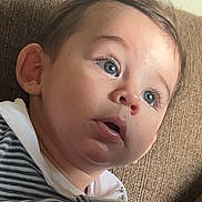 Dan a rejoint le concours — aidez-le/la à gagner de superbes lots ! toddler, child, face, blue_eyes, striped_clothing, hoodie, couch, indoor, curious, young_child, portrait, casual, seated, expression, skin, hair, person, closeup, comfort, relaxed