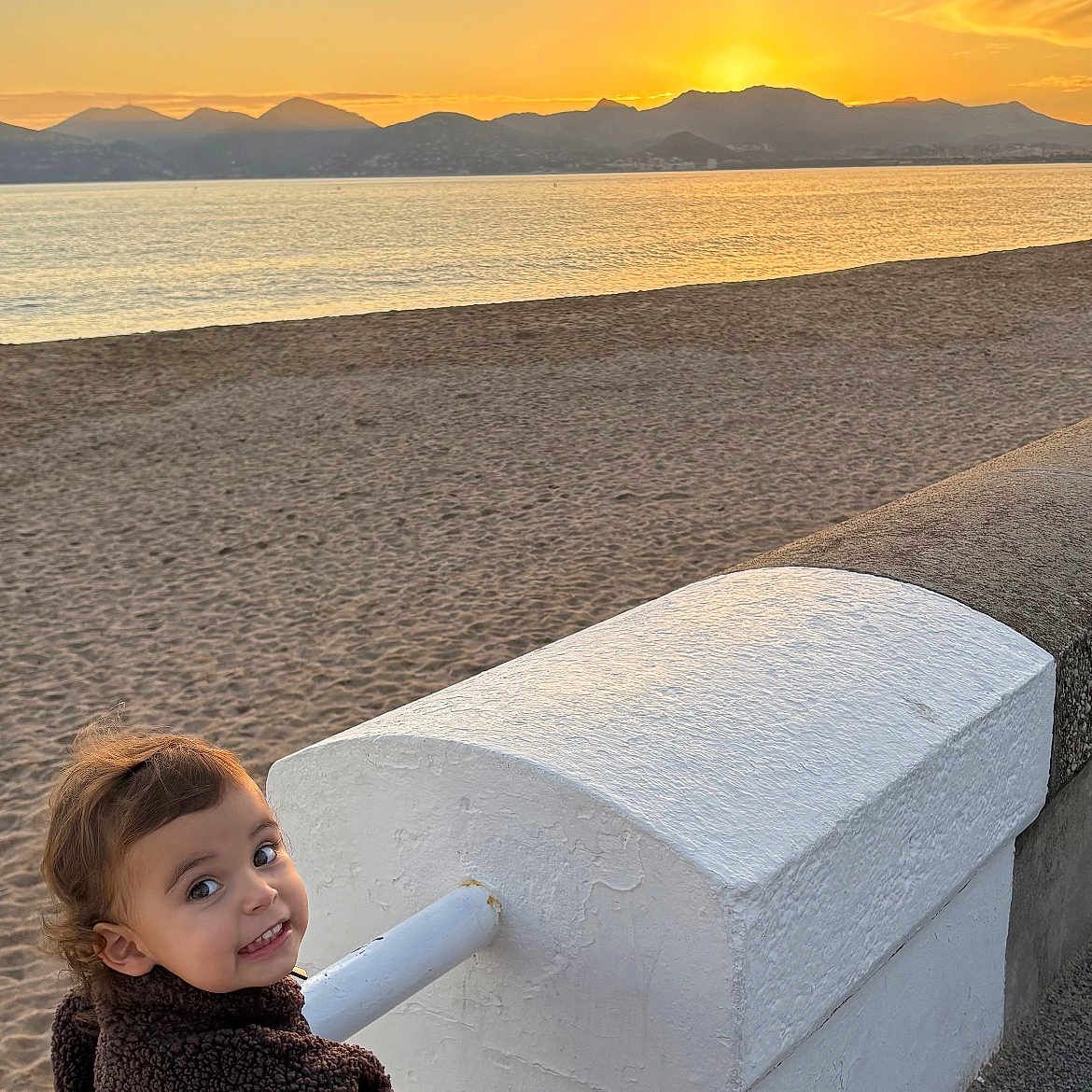 Carmela participe au concours pour gagner de l'argent avec cette photo : beach, child, happy, jacket, leisure, mountains, nature, outdoor, person, pink, play, sand, scenic, scooter, sky, smile, sunlight, sunset, toddler, water