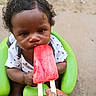 baby, child, curly_hair, popsicle, red, green_seat, hand, outdoor, summer, food, toddler, person, cute, snack, closeup, skin, happy, infant, sitting, casual_clothing