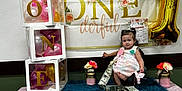 Anita joined the competition — help win amazing prizes! baby, balloons, banner, birthday, blue_fur, celebration, child, cute, decorations, dress, first_birthday, flowers, gold_balloon, indoors, money, party, person, pink, smiling, table