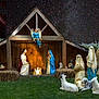 angel, animal_statues, baby_jesus, barn, celebration, dog, garden, grass, hay, holiday, joseph, mary, nativity_scene, night_sky, outdoor, religious, sheep, stars, statues, trumpet