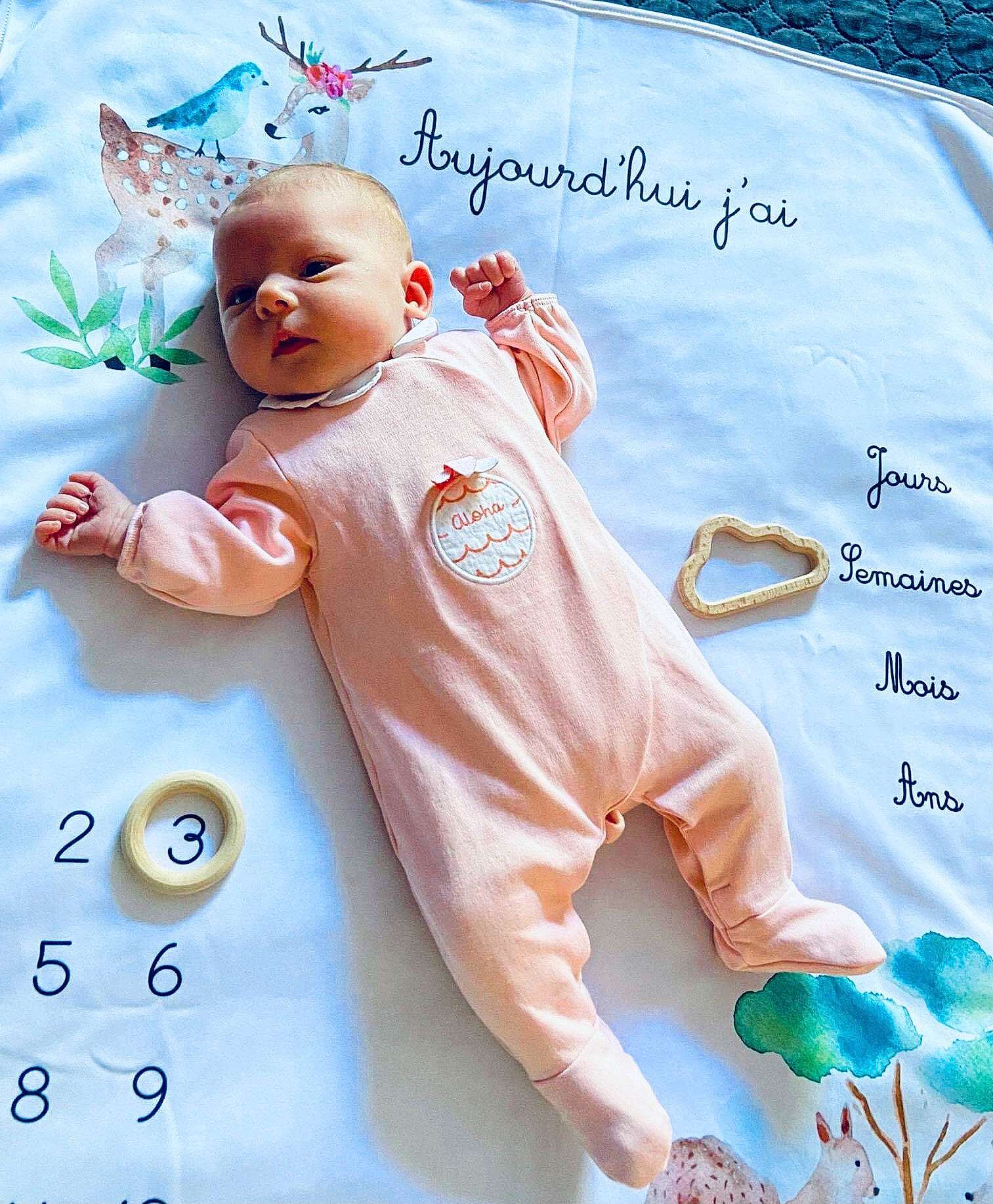Maëlle a rejoint le concours — aidez-le/la à gagner de superbes lots ! baby, baby_products, baby_toddler_clothing, blue, child, finger, font, gesture, handwriting, happy, linens, pattern, peach, person, product, sleeve, t_shirt, textile, toddler