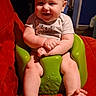 baby, child, smile, green_baby_seat, red_couch, indoor, person, cute, happy, sitting, infant, legs, feet, short_sleeve_shirt, home, furniture, face, head, light, cozy