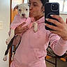 affection, casual, chair, dog, hand, home, hoodie, indoor, kiss, love, mirror, pet, phone, pink_clothing, puppy, selfie, sweatpants, window, woman, wooden_floor