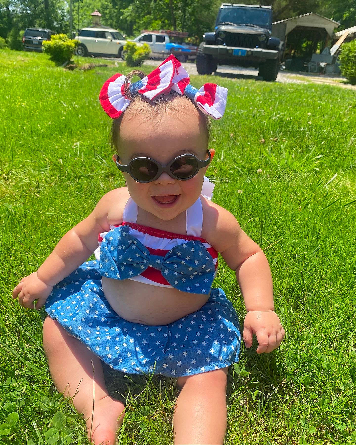 Demi is registered to the contest to win money with this photo: baby_toddler_clothing, blue, car, eyewear, fun, glasses, goggles, grass, green, happy, hat, head, headgear, leisure, person, plant, smile, summer, sunglasses, tree
