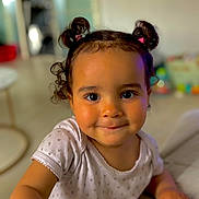 Melia a rejoint le concours — aidez-le/la à gagner de superbes lots ! toddler, child, smiling, pigtails, curly_hair, indoor, portrait, cute, baby, person, face, expression, clothing, white_shirt, hand, candid, happy, young, skin, closeup