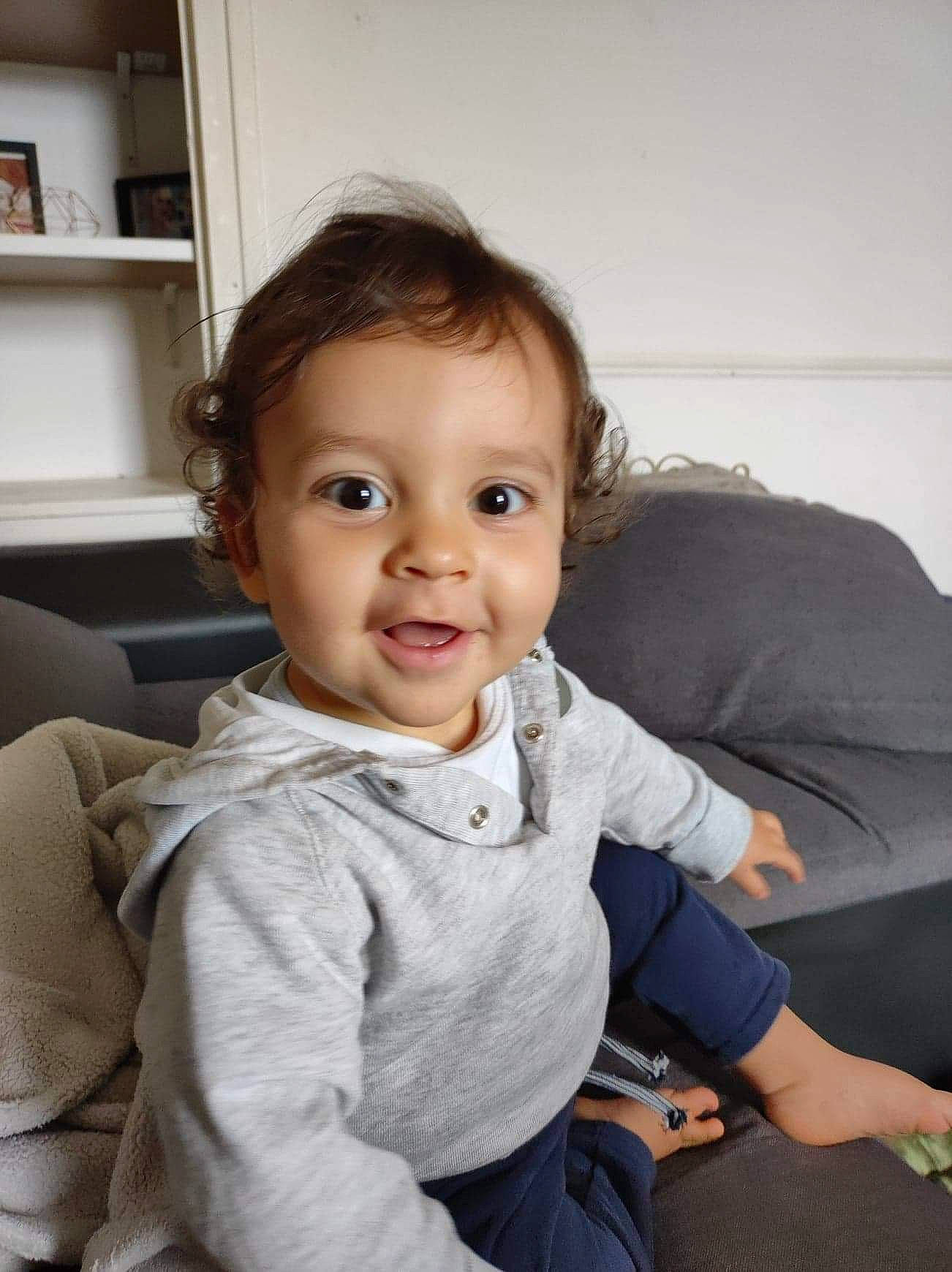 Isaac participe au concours pour gagner de l'argent avec cette photo : arm, baby_toddler_clothing, cheek, comfort, couch, eye, face, flash_photography, fun, hair, happy, head, iris, neck, person, shelf, shoulder, skin, sleeve, smile