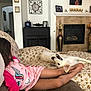 Teddy is registered to the contest to win money with this photo: child, dog, pajamas, couch, bed, living_room, fireplace, family_photos, home_decor, floral_pattern, relaxed, cute, indoor, comfort, smiling_dog, legs, bowl, fruit, brown_hair, pink_clothing