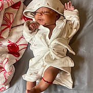 Honestii joined the competition — help win amazing prizes! baby, infant, blanket, bed, robe, hood, foot, hand, bracelet, smile, sleepwear, fabric, texture, toddler, lying_down, cute, comfort, soft, indoor, child