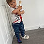 toddler, child, indoor, carpet, white_wall, door, bottle, holding, shirt, spiderman, pants, camo, blue, slipper, sock, standing, expression, looking_up, floor, mismatched_footwear