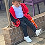 child, sitting, red_jacket, white_shirt, black_pants, white_sneakers, toy_gun, brick_wall, outdoor, pavement, purple_chairs, person_in_jeans, playful, casual, daylight, young, happy, relaxed, concrete, urban