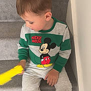 Jaxon joined the competition — help win amazing prizes! child, boy, stairs, mickey_mouse, sweatshirt, gray_pants, white_shoes, carpet, indoor, toy, sitting, looking_down, casual_clothing, young, side_view, hand, footwear, wall, home, portrait