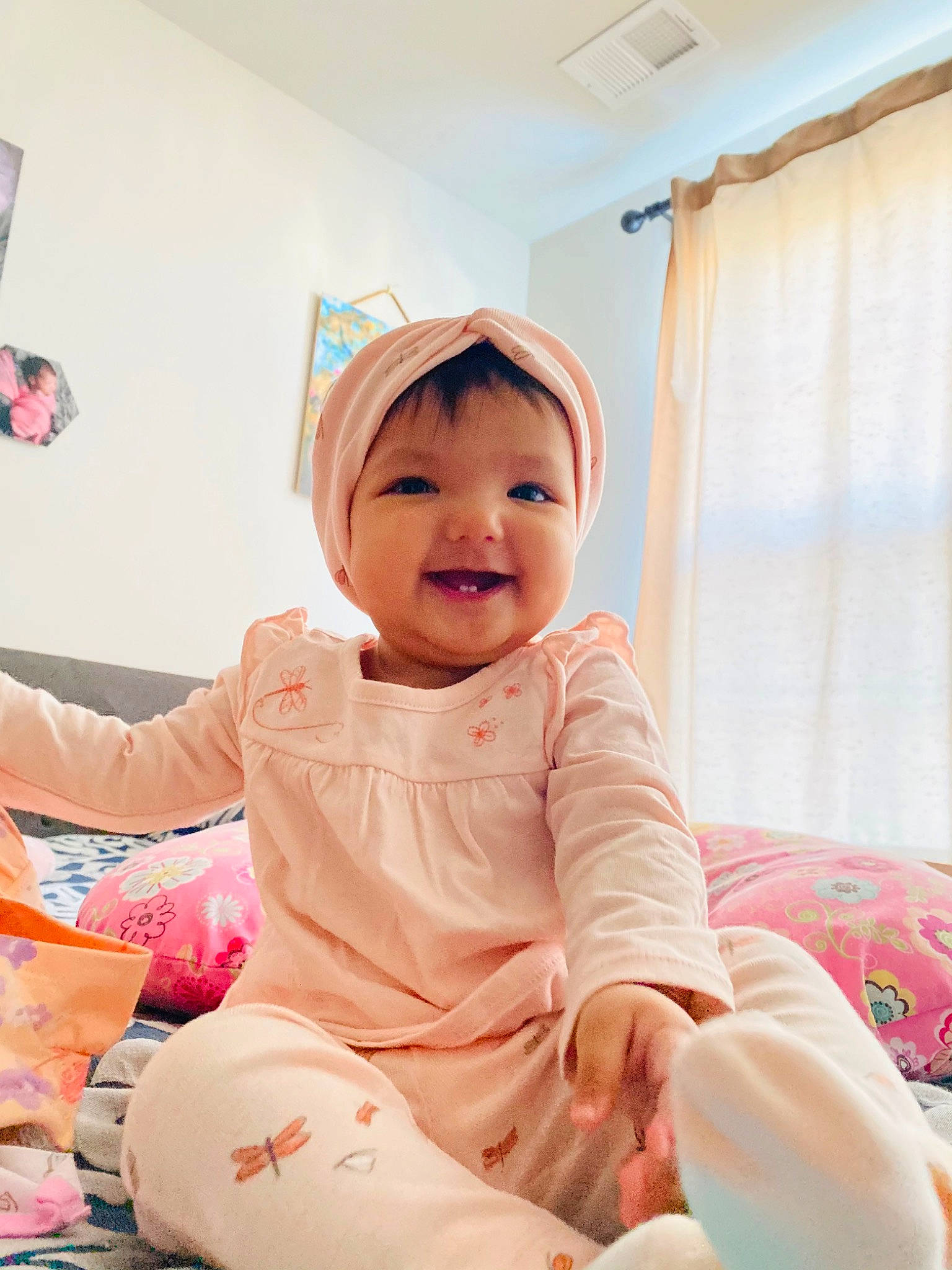 Aarvi is registered to the contest to win money with this photo: baby, baby_toddler_clothing, child, comfort, curtain, flooring, foot, fun, happy, human_leg, knee, magenta, peach, person, pink, room, sitting, sleeve, smile, sock