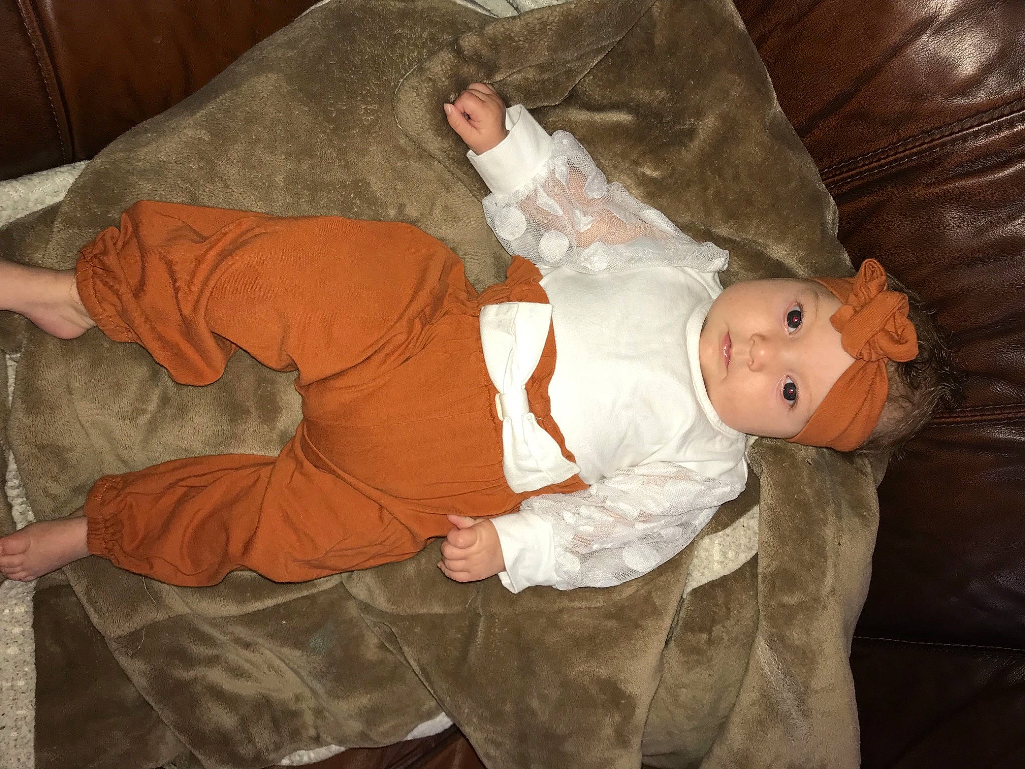 Alaia is registered to the contest to win money with this photo: baby, baby_toddler_clothing, child, comfort, costume, flesh, headwear, human_body, lap, person, room, sitting, sleeve, textile, toddler, vertebrate, wood, wrist