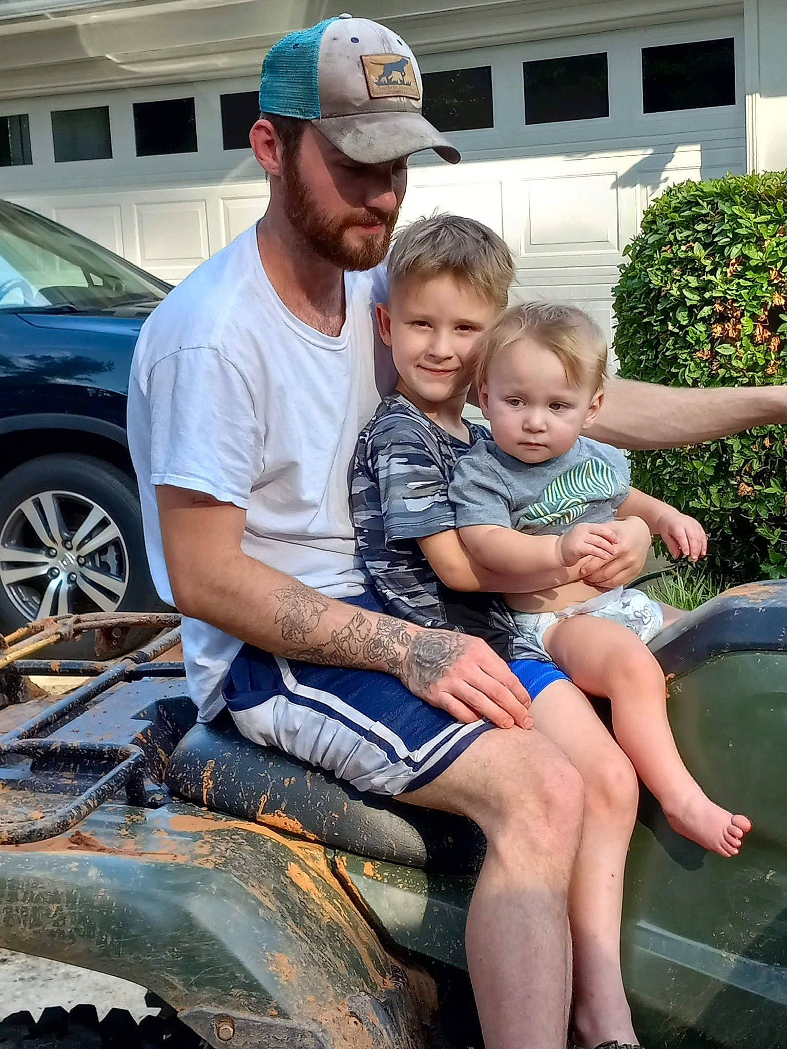 Braxtyn is registered to the contest to win money with this photo: automotive_exterior, automotive_tire, baseball_cap, bumper, cap, car, happy, hat, headwear, hood, joy, leg, leisure, motor_vehicle, muscle, person, plant, shorts, tire, toddler