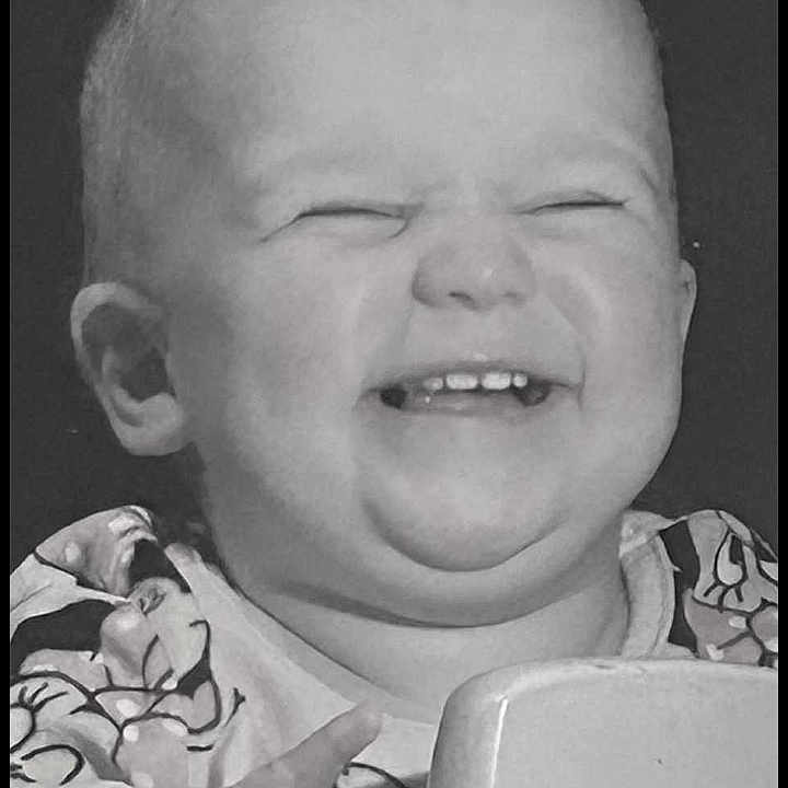 Ava-Rae is registered to the contest to win money with this photo: baby, black_and_white, child, closeup, cute, expression, face, furniture, hand, happy, holding, indoor, infant, joy, patterned_clothing, person, portrait, smiling, tooth, young