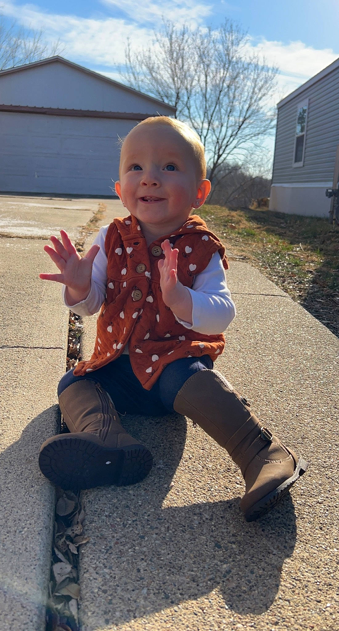 Melody joined the competition — help win amazing prizes! arm, asphalt, baby, baby_toddler_clothing, finger, footwear, fun, gesture, happy, joy, leg, leisure, person, road_surface, sitting, sky, sleeve, smile, sneakers, thumb