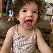 Trinity is registered to the contest to win money with this photo: toddler, child, curly_hair, smiling, pink_tank_top, indoor, happy, face, person, clothing, expression, cute, portrait, young_child, playful, home, furniture, colorful, joy, cheerful