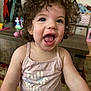 toddler, child, curly_hair, smiling, pink_tank_top, indoor, happy, face, person, clothing, expression, cute, portrait, young_child, playful, home, furniture, colorful, joy, cheerful