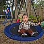 toddler, child, swing, playground, outdoor, plaid_shirt, brown_pants, sneakers, trees, fence, backyard, leaves, grass, rope, toy, daytime, person, young_child, casual_clothing, calm