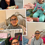 Kiara is registered to the contest to win money with this photo: child, girl, glasses, smiling, indoors, bedroom, blanket, pillow, furniture, casual_clothing, happy, portrait, home, cozy, seated, young, person, curly_hair, multicolored, blanket_pattern