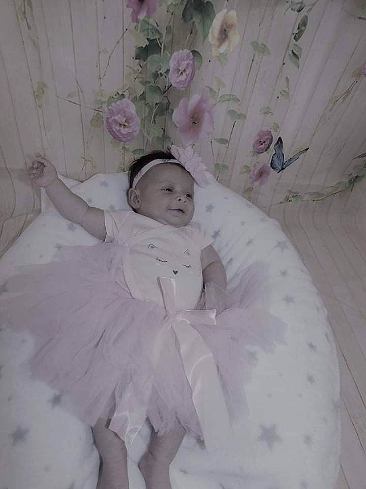 Louna participe au concours pour gagner de l'argent avec cette photo : baby_products, baby_toddler_clothing, bed, bedding, bridal_accessory, comfort, dress, eye, face, flooring, fur, hair, head, linens, pattern, person, pink, room, smile, textile