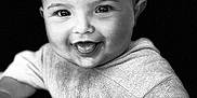 Natcho a rejoint le concours — aidez-le/la à gagner de superbes lots ! baby, baby_clothing, black_background, cheeks, child, closeup, cute, expression, eyes, face, happy, head, infant, person, portrait, smiling, sweater, tongue, wet_mouth, young_child