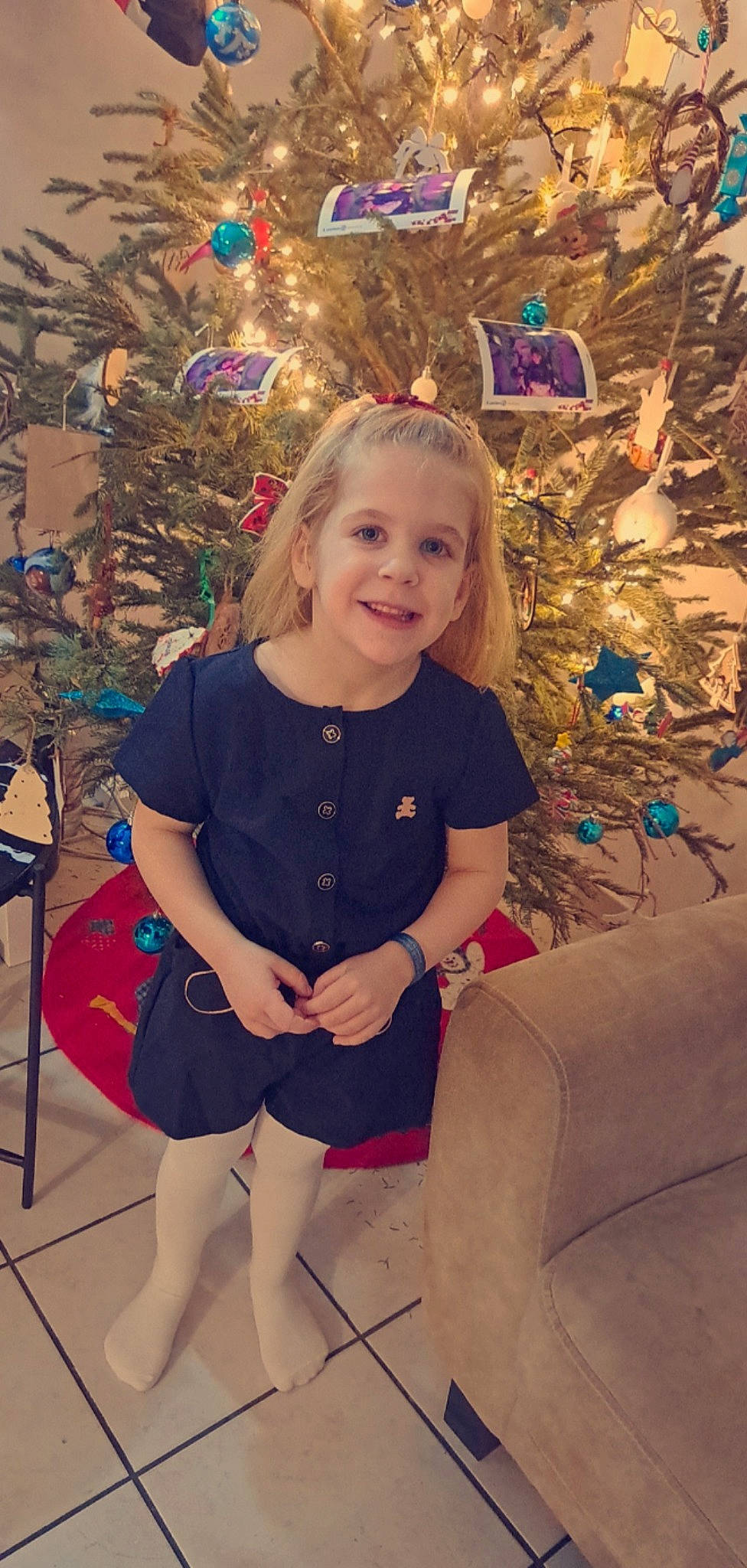 Lylou a rejoint le concours — aidez-le/la à gagner de superbes lots ! blond, child, christmas, christmas_decoration, christmas_eve, christmas_ornament, christmas_tree, event, fun, happy, holiday, human_leg, joy, knee, ornament, pattern, person, sitting, smile, thigh