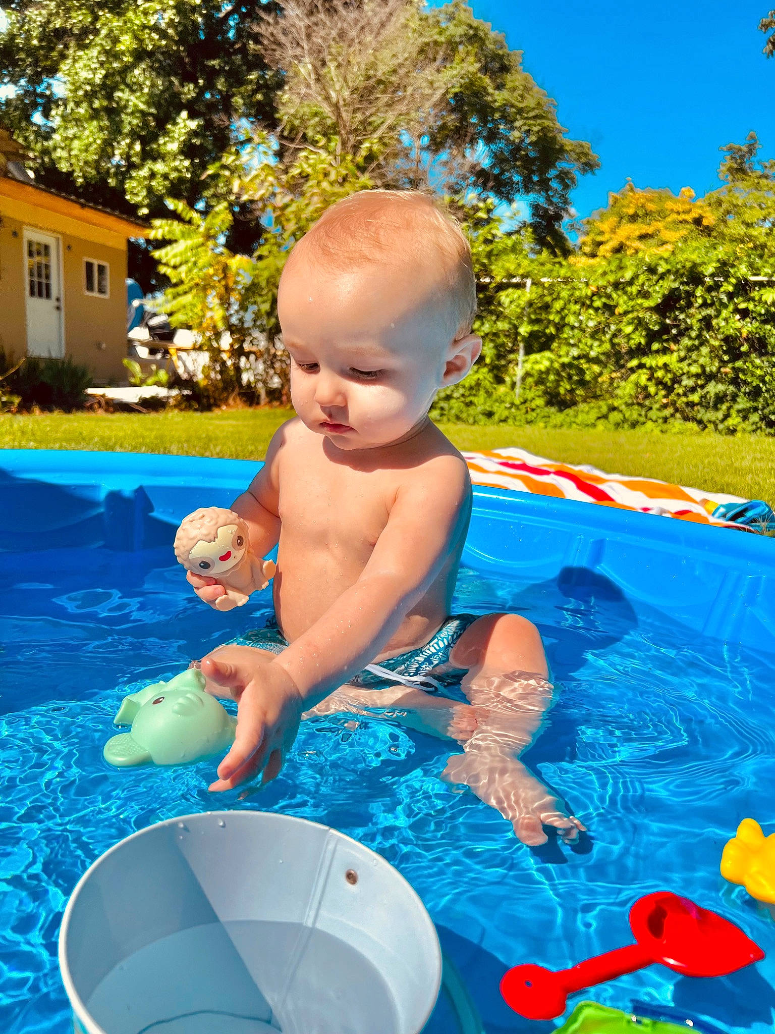Brayden is registered to the contest to win money with this photo: aqua, azure, baby, bathing, blue, child, electric_blue, fun, grass, happy, leisure, person, plant, recreation, sky, summer, swimming_pool, toddler, tree, water