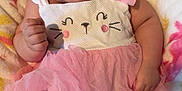 Truly is registered to the contest to win money with this photo: baby, infant, child, pink_clothing, white_clothing, blanket, cute, portrait, face, smiling, tutu, leggings, hand, lying_down, indoors, soft_texture, curly_hair, person, young_child, cozy