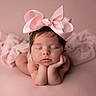 Angelina is registered to the contest to win money with this photo: newborn, baby, pink_bow, sleeping, soft_texture, portrait, infant, cute, studio_photography, pink_background, resting, peaceful, adorable, hands_under_chin, headwear, child, baby_pose, smooth_skin, calm, close_up