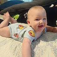 Logan joined the competition — help win amazing prizes! baby, smiling, tummy, bed, pillow, blanket, infant, clothing, cute, happy, child, indoor, person, reaching, soft, comfortable, expression, young, playful, face