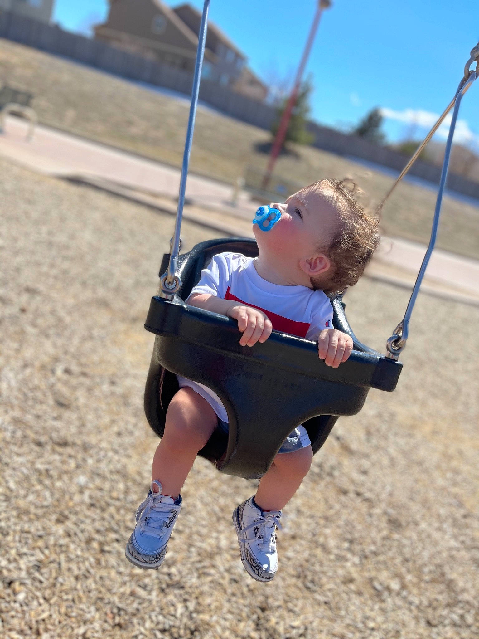 Desmond is registered to the contest to win money with this photo: child, city, electric_blue, fun, grass, happy, landscape, leisure, outdoor_play_equipment, person, playground, recreation, rope, shorts, sky, slope, soil, sports, swing, t_shirt