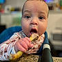 baby, child, face, hand, food, kitchen, highchair, table, curious, indoors, closeup, person, expression, skin, eyes, mouth, clothing, furniture, blurred_background, holding