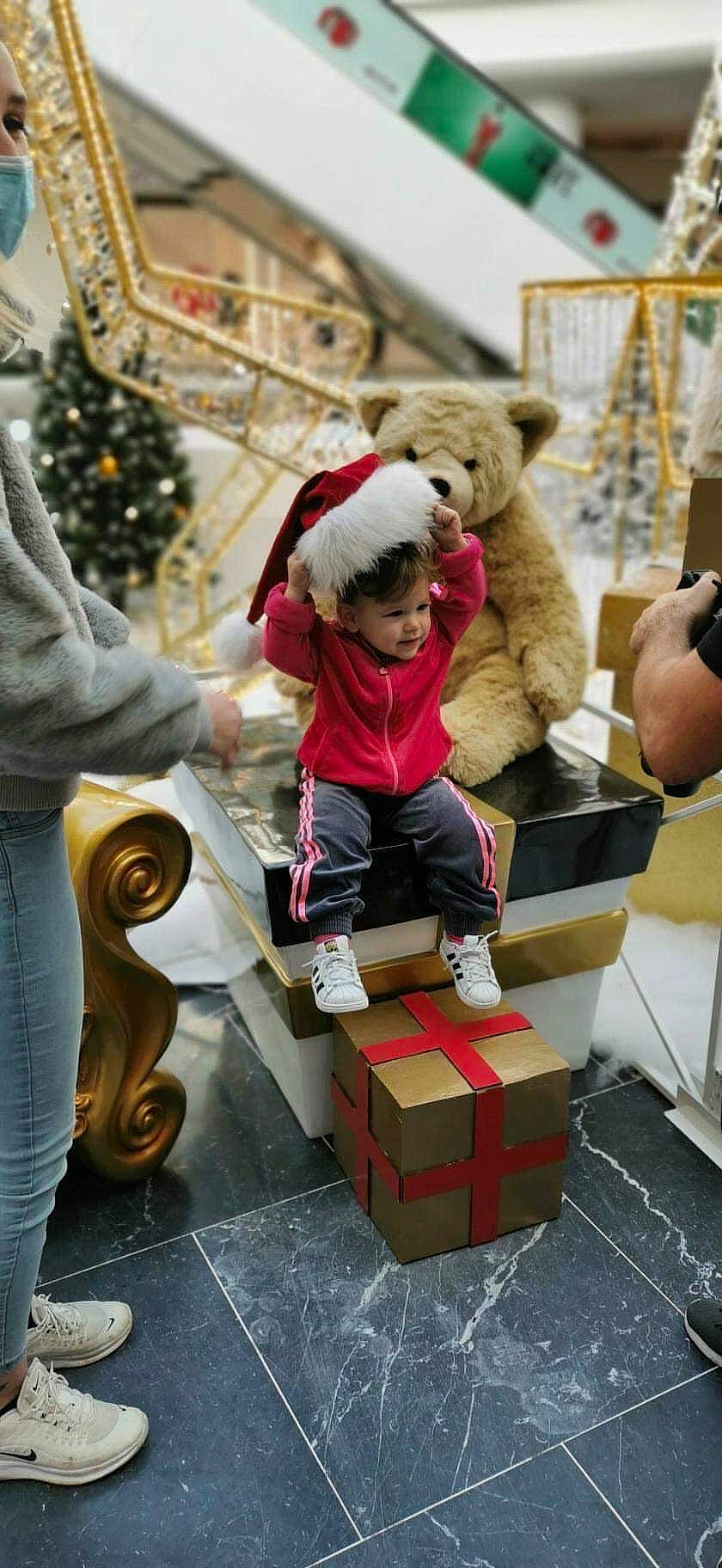 Kaylee participe au concours pour gagner de l'argent avec cette photo : boot, box, cardboard, carton, child, event, fictional_character, fun, fur, holiday, human, leisure, package_delivery, person, room, shipping_box, stuffed_toy, teddy_bear, toy, tree