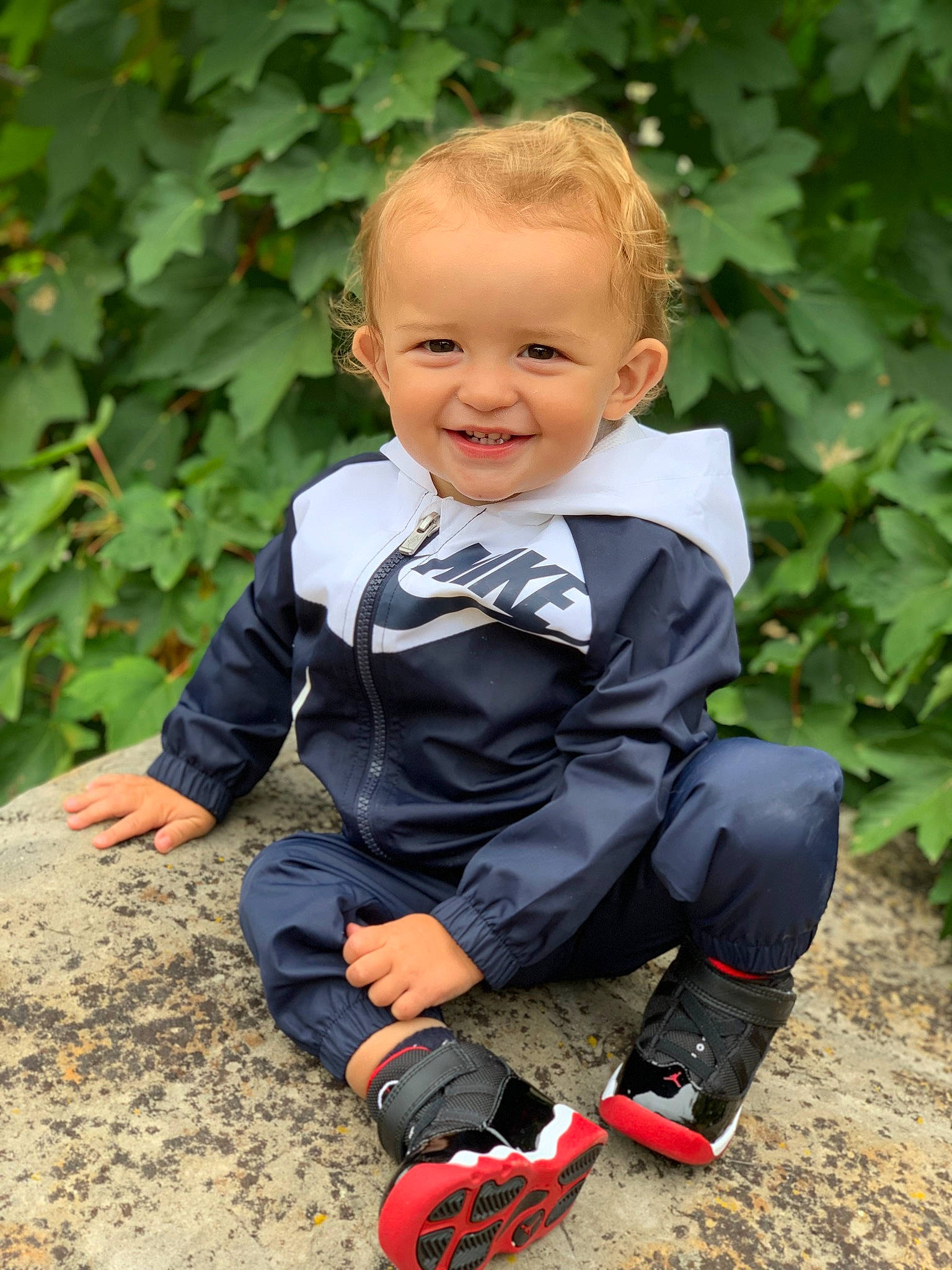 Zayne is registered to the contest to win money with this photo: baby, child, child_model, footwear, joy, leaf, male, outerwear, person, photography, plant, play, shoe, sitting, smile, toddler