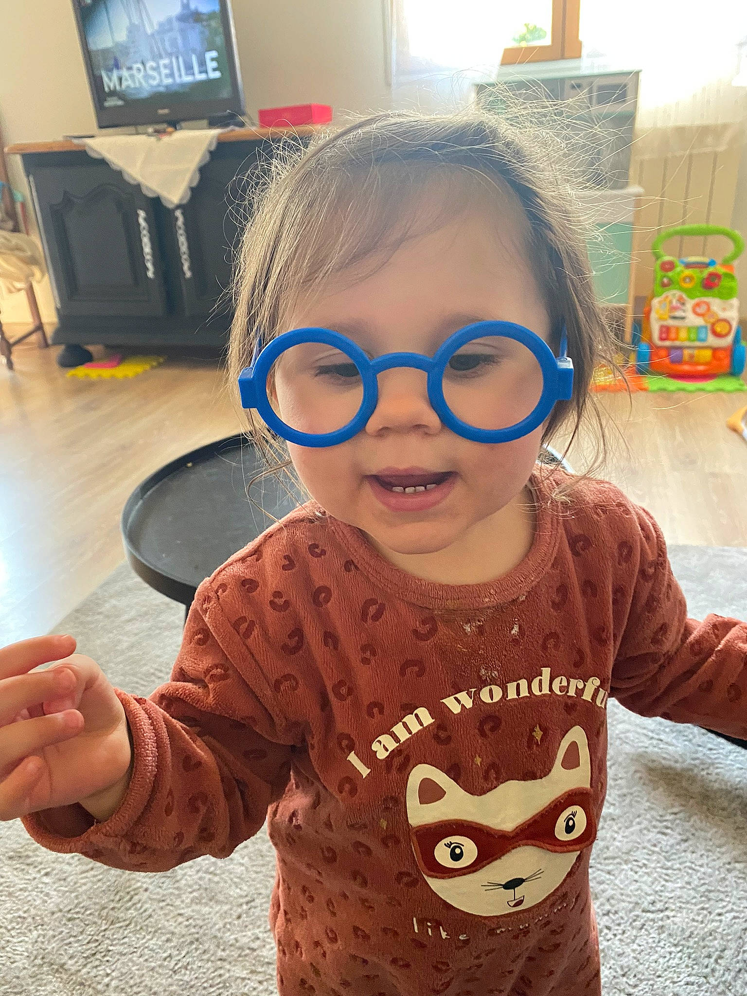 Mara participe au concours pour gagner de l'argent avec cette photo : baby_toddler_clothing, child, computer_monitor, cool, eye, eyewear, facial_expression, happy, head, human, mouth, nose, outerwear, person, skin, sleeve, smile, standing, t_shirt, toddler