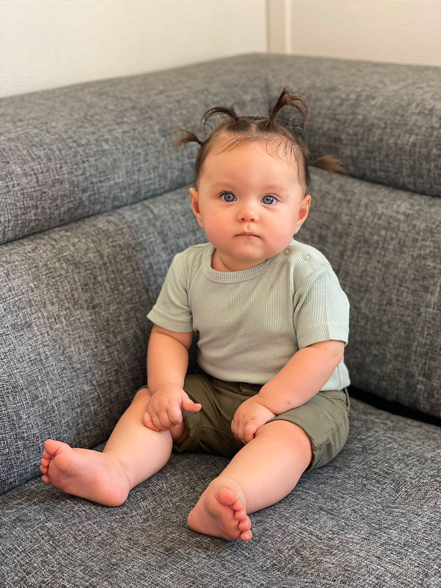 Alya a rejoint le concours — aidez-le/la à gagner de superbes lots ! baby, baby_toddler_clothing, barefoot, cheek, comfort, couch, eye, face, flooring, foot, hair, head, human_body, human_leg, knee, person, sitting, skin, sleeve, toddler