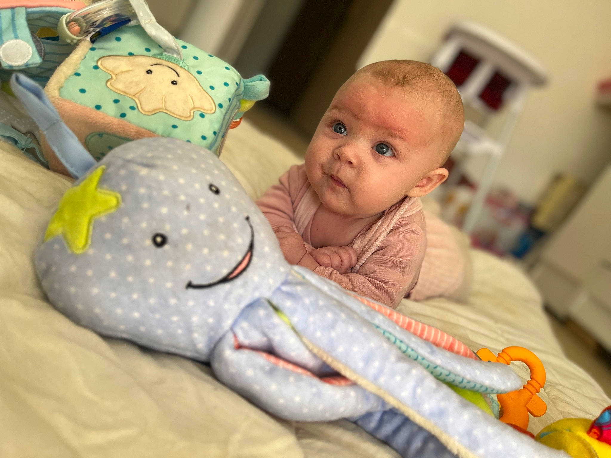 Ema a rejoint le concours — aidez-le/la à gagner de superbes lots ! baby, baby_products, baby_safety, baby_toddler_clothing, baby_toys, bedding, carmine, child, comfort, fun, linens, pattern, person, picture_frame, play, plush, room, sitting, stuffed_toy, toddler