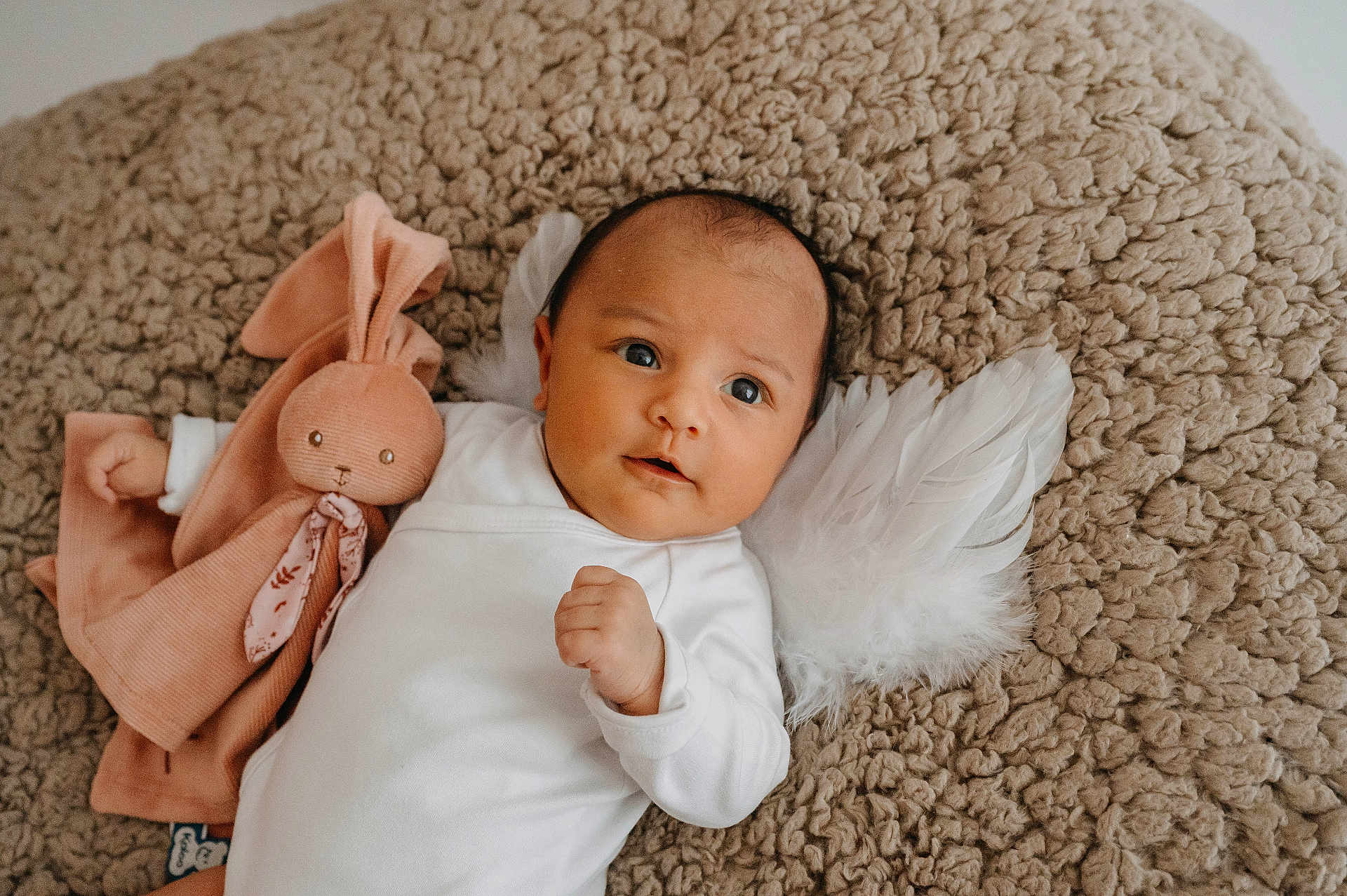 Kalena participe au concours pour gagner de l'argent avec cette photo : baby, infant, toy, bunny, plush_toy, feathers, angel_wings, blanket, white_clothing, cute, portrait, lying_down, soft_texture, child, indoors, newborn, face, hand, expression, cozy