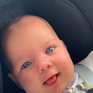 Capucine participe au concours pour gagner de l'argent avec cette photo : baby, infant, face, blue_eyes, smile, tongue_out, car_seat, seatbelt, white_clothing, close_up, child, cute, happy, skin, head, person, portrait, young, seat, babywearing