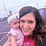 Everly joined the competition — help win amazing prizes! baby, woman, child, holding, smiling, headband, pink_clothing, outdoor, parking_lot, power_lines, sign, person, portrait, happy, face, hair, casual, daylight, toddler, family