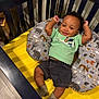 Sawyer joined the competition — help win amazing prizes! baby, crib, pillow, yellow_mattress, animal_print, green_shirt, shorts, socks, smiling, happy, indoor, wooden_floor, child, infant, cute, relaxed, playful, person, portrait, cozy