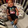 baby, infant, crib, pillow, superhero, clothing, shoes, pattern, smiling, cute, child, indoor, person, apparel, footwear, happy, resting, colorful, marvel, decor
